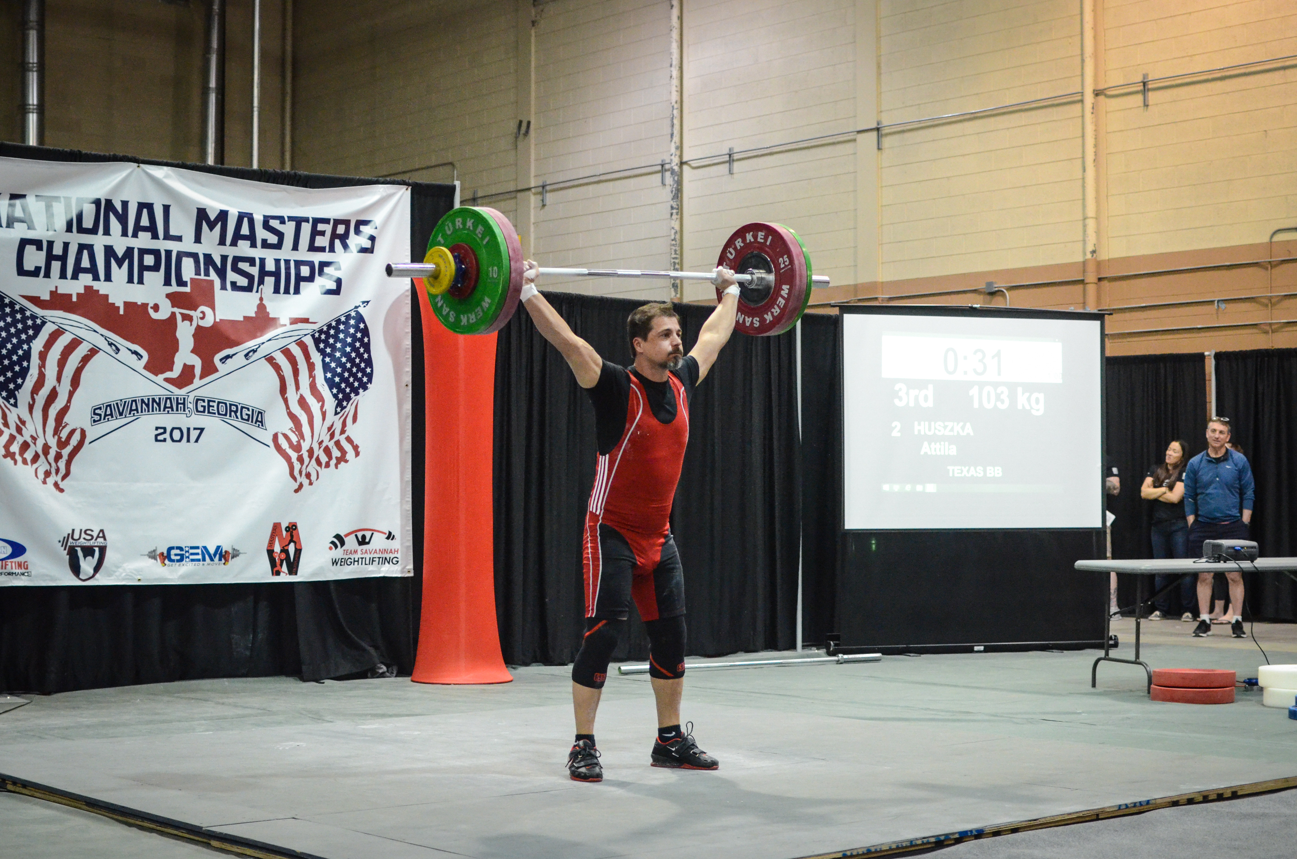 Athlete performing overhead lift at competition